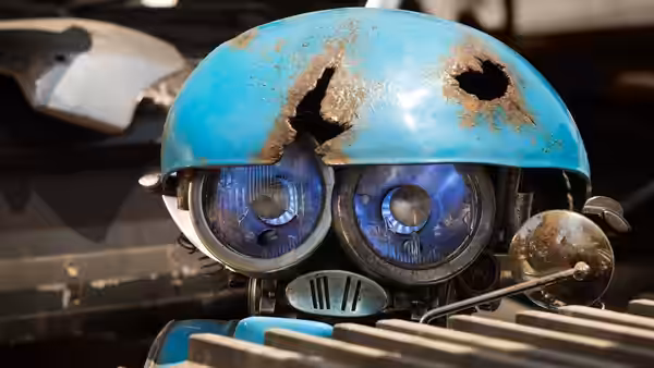 A small blue robot peers through a weathered helmet