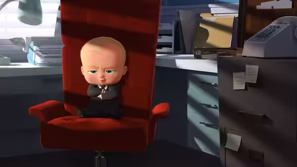 Boss Baby sits with folded arms in a red office chair