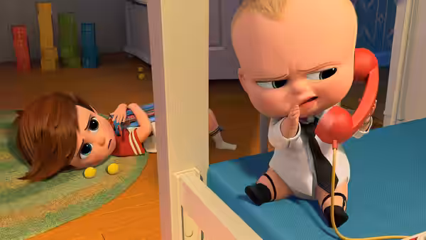 Tim lies on the floor while Boss Baby talks on a red telephone