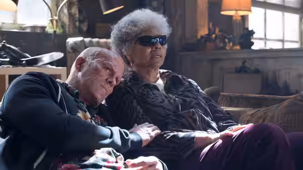 Deadpool rests his head on Blind Al's shoulder inside her home