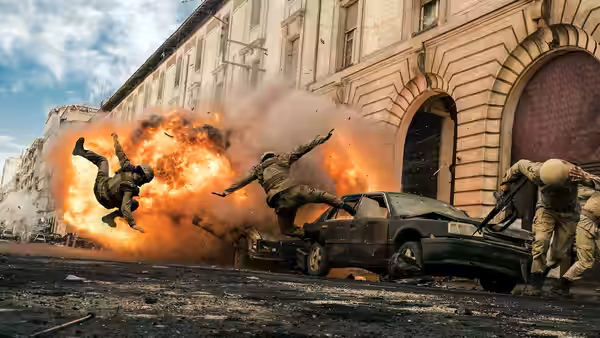Soldiers are thrown into the air as an explosion erupts beside a car on a city street