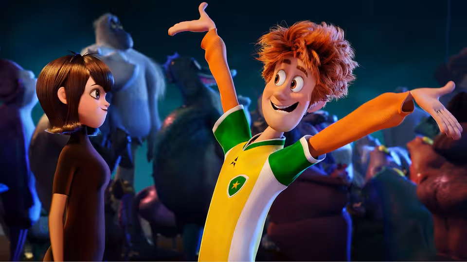 Johnny (Andy Samberg) throws his arms wide beside Mavis (Selena Gomez) among dancing monsters