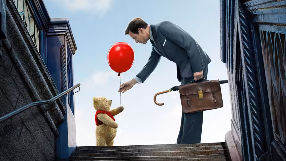 Christopher Robin offers Winnie the Pooh a red balloon on a city stairway
