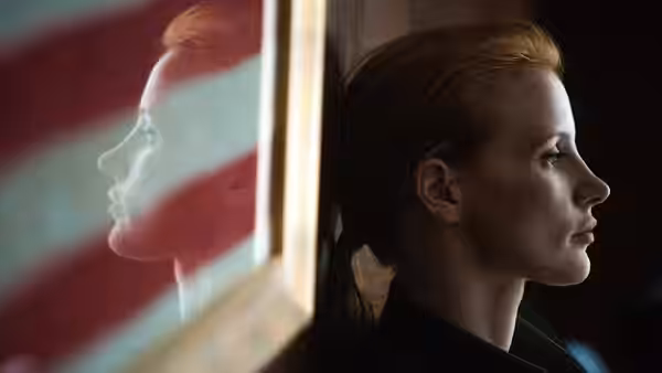 Maya (Jessica Chastain) in profile beside an American flag reflection