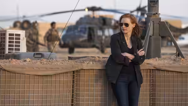 Maya (Jessica Chastain) leaning against sandbags at a military base