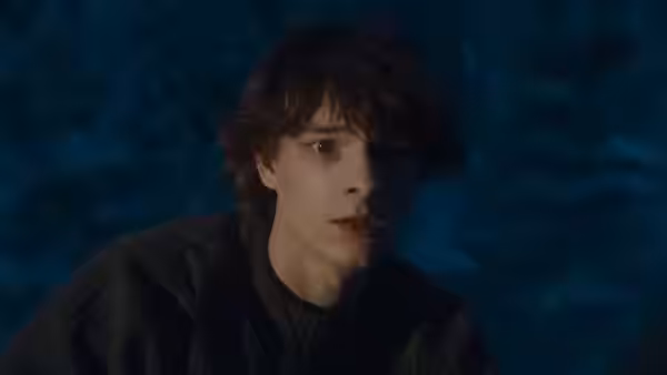 Finn (Mason Thames) sits in darkness with a concerned expression on his face