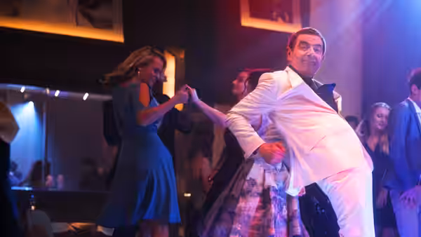 Johnny English (Rowan Atkinson) dances with women at a nightclub