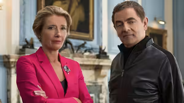 The Prime Minister (Emma Thompson) stands beside Johnny English (Rowan Atkinson) in a formal room