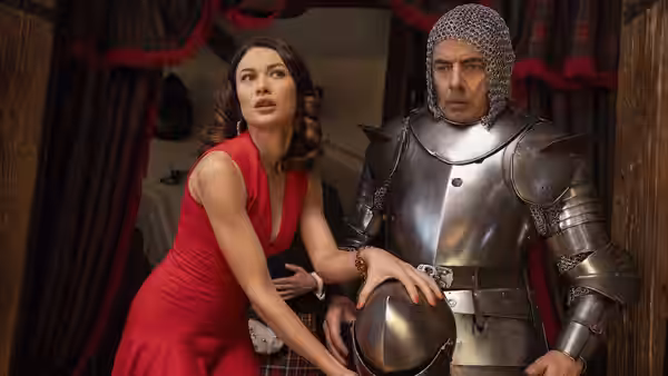 Ophelia Bhulatova (Olga Kurylenko) and Johnny English (Rowan Atkinson) stand together in medieval armor