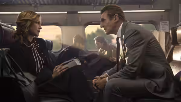 Joanna (Vera Farmiga) speaks with Michael MacCauley (Liam Neeson) across a train seat