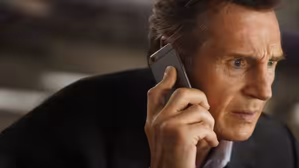 Michael MacCauley (Liam Neeson) holds a phone to his ear aboard the train