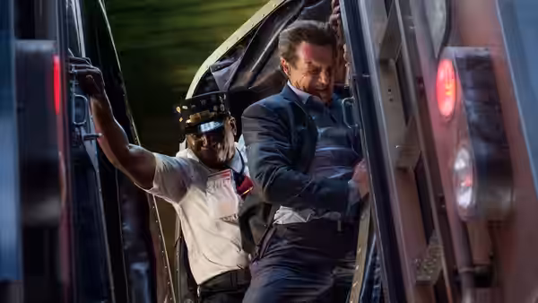 Michael MacCauley (Liam Neeson) struggles in a train doorway with a railway worker behind him