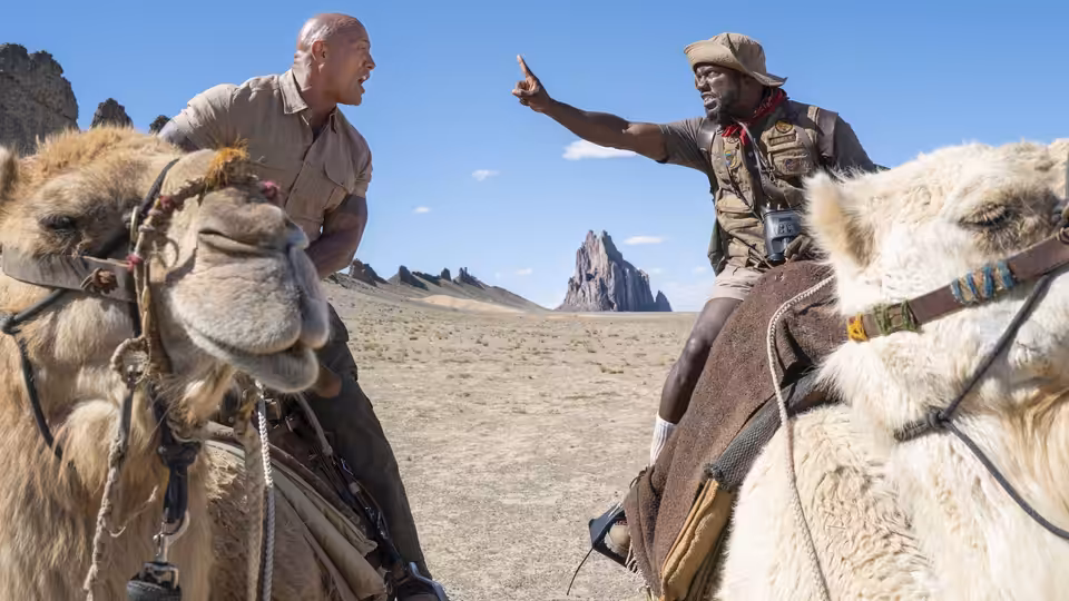 Dr. Smolder Bravestone (Dwayne Johnson) and Franklin Finbar (Kevin Hart) ride camels through the desert