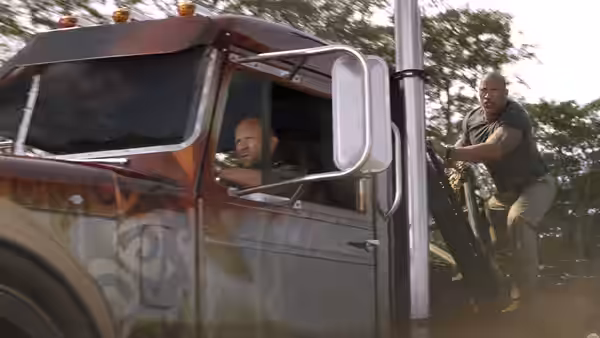 Luke Hobbs (Dwayne Johnson) clings to the side of a moving truck