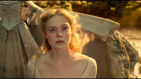 Princess Aurora (Elle Fanning) looks upward beside pale stone ruins