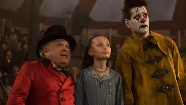 Max Medici (Danny DeVito), Milly Farrier (Nico Parker), and a painted clown look upward