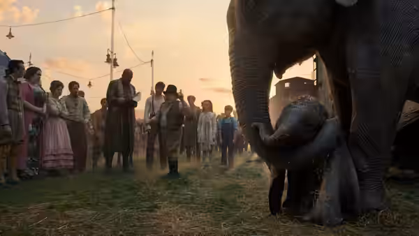 Holt Farrier (Colin Farrell) and onlookers watch a mother elephant nuzzle Dumbo
