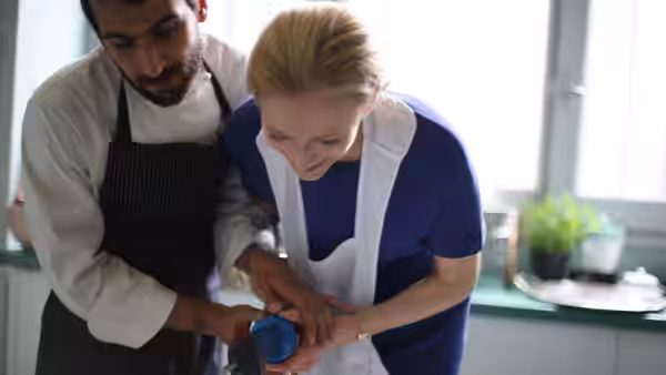 Emma Recchi (Tilda Swinton) and Antonio Biscaglia (Edoardo Gabbriellini) prepare food together in a kitchen