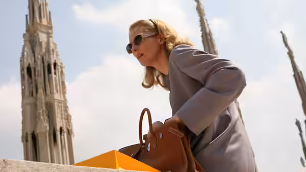 Emma Recchi (Tilda Swinton) leans over her handbag beneath a Milan cathedral spire