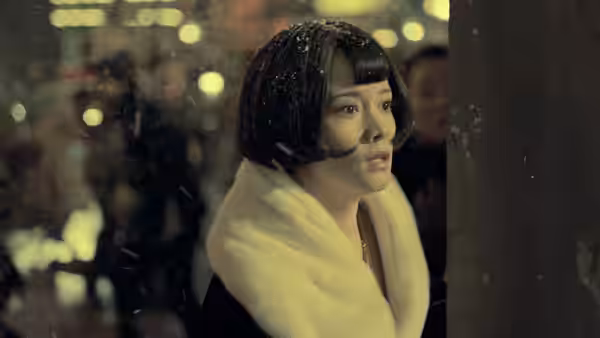 Yang Huimin (Tang Yixin) peers around a post in a snowy street