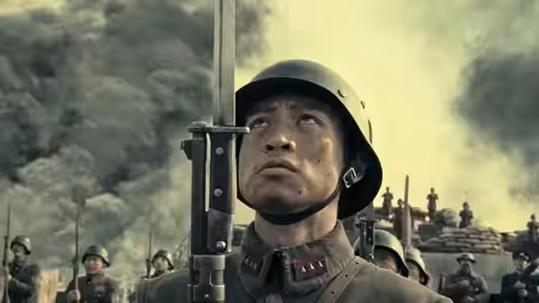 A helmeted Chinese soldier looks upward as smoke billows behind his unit