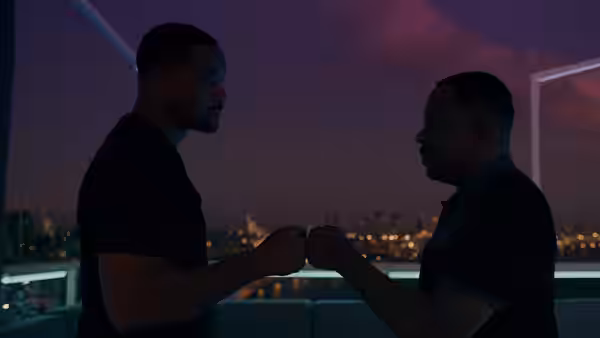 Mike (Will Smith) and Marcus (Martin Lawrence) bump fists on a balcony at dusk