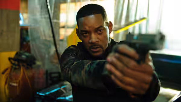 Mike (Will Smith) points his gun inside a cluttered room behind police tape