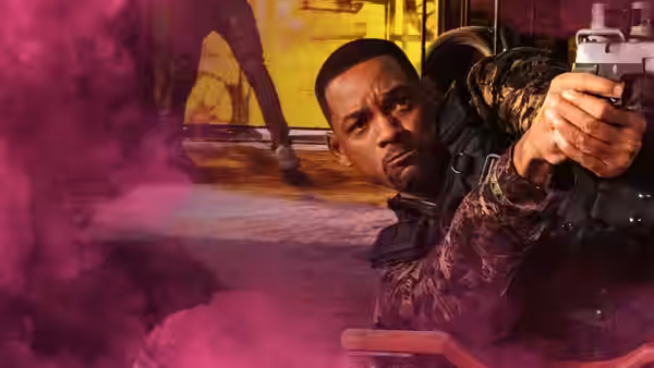 Mike (Will Smith) aims a pistol through swirling smoke in a dim interior