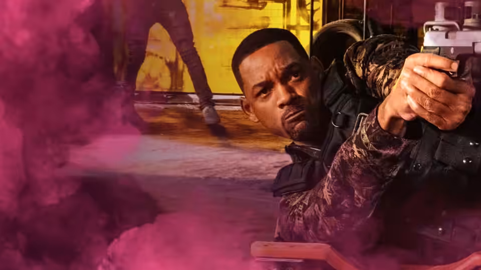 Mike (Will Smith) aims a pistol through swirling smoke in a dim interior