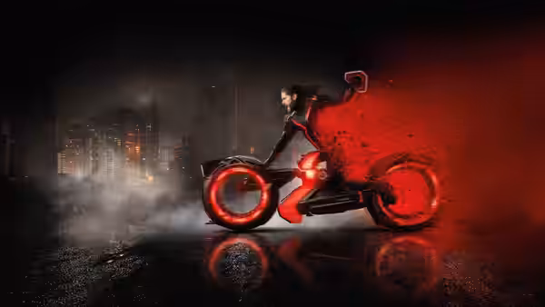 A rider on a red motorcycle speeds through a dark city trailing red particles