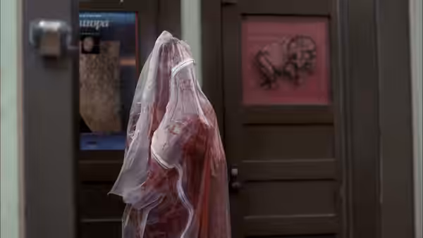 A blood-soaked figure wrapped in plastic standing before doors