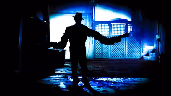 Fred Krueger (Robert Englund) standing with arms outstretched in shadow