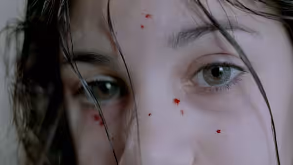 Close-up of eyes with red drops on a wet face