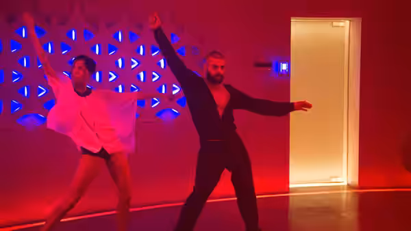 Nathan (Oscar Isaac) and Kyoko (Sonoya Mizuno) dance with arms raised in a red room