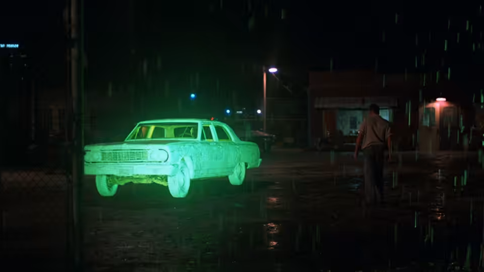 A glowing green sedan sits parked on a rain-slicked street at night