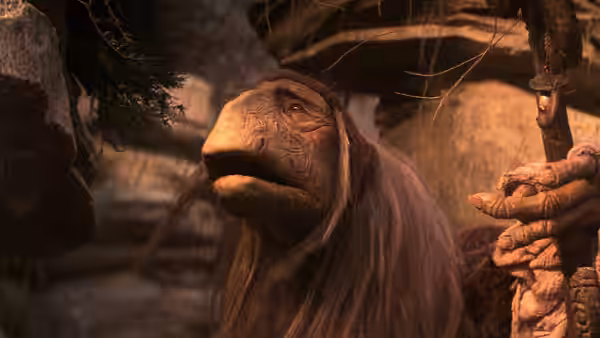A long-haired urRu mystic sits inside a dim, rocky dwelling