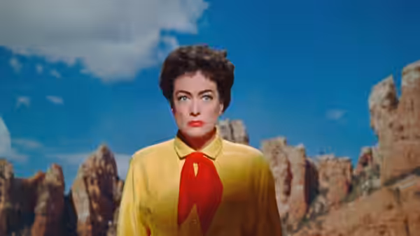 Vienna (Joan Crawford) stands before towering rock formations