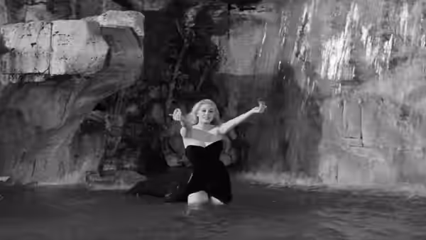 Sylvia (Anita Ekberg) kneels in the Trevi Fountain with her arms raised