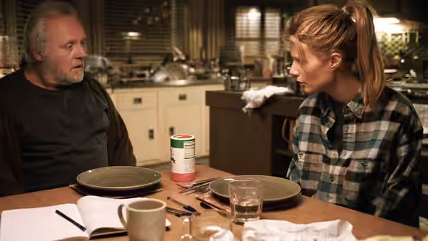 Robert (Anthony Hopkins) and Catherine (Gwyneth Paltrow) sit across from each other at a cluttered kitchen table