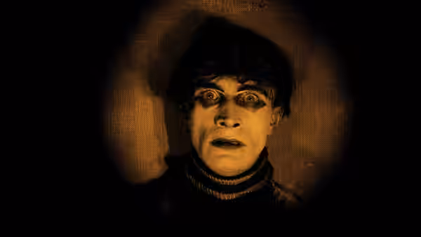 Cesare staring forward with wide painted eyes in close-up