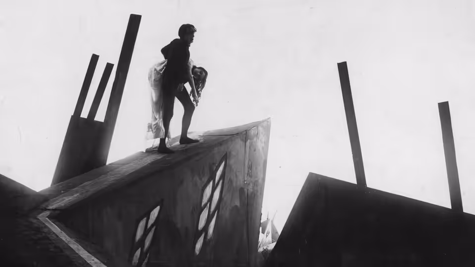 Cesare carrying Jane across the angled rooftops of the town
