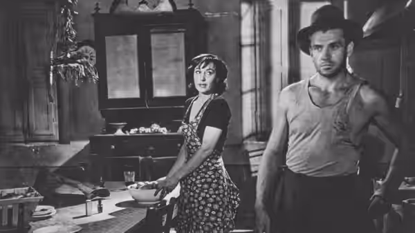 Gino Costa (Massimo Girotti) stands beside Giovanna Bragana (Clara Calamai) in a kitchen