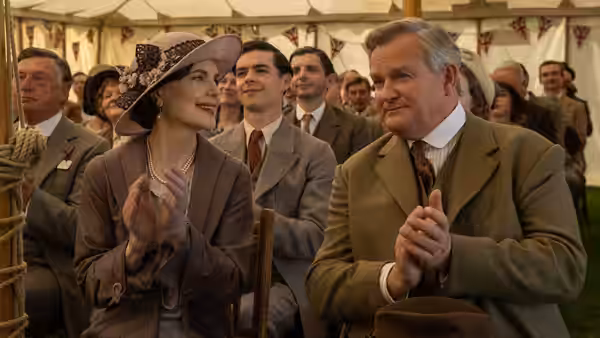 Robert Crawley (Hugh Bonneville) clapping at an outdoor gathering