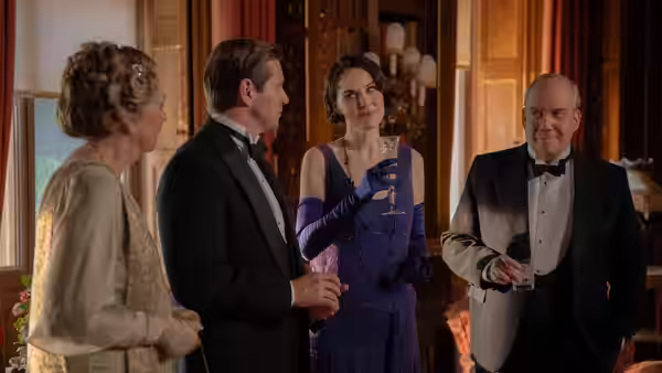 Lady Mary (Michelle Dockery) holding a glass among formally dressed guests