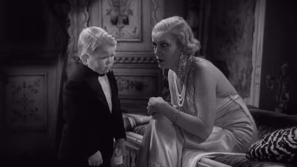 Hans (Harry Earles) sits beside Cleopatra (Olga Baclanova) in an ornate room