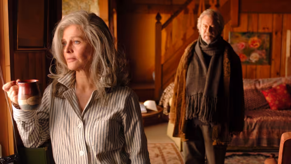 Fiona (Julie Christie) holds a mug while Grant (Gordon Pinsent) stands behind her at home