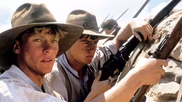 two soldiers in slouch hats aiming rifles from rocky cover