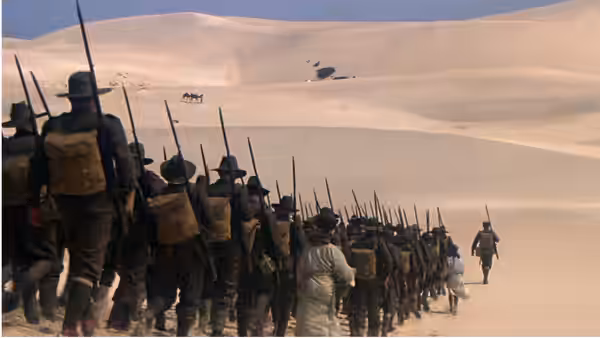 a line of soldiers marching across sand dunes in the desert