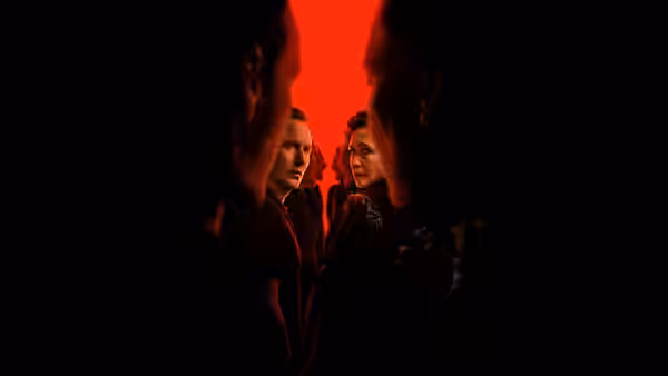 Ed Warren (Patrick Wilson) and Lorraine Warren (Vera Farmiga) facing forward in red light
