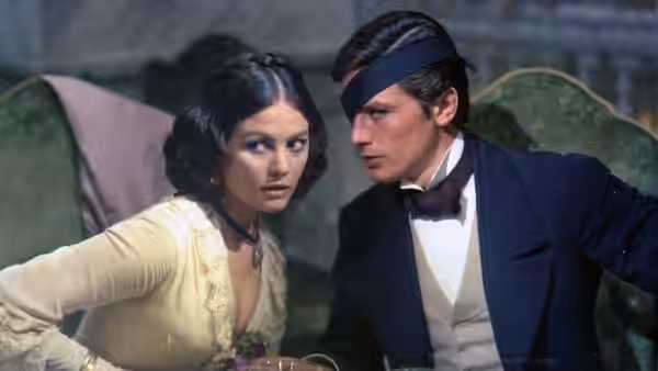 Angelica (Claudia Cardinale) and Tancredi (Alain Delon) lean close together on a sofa